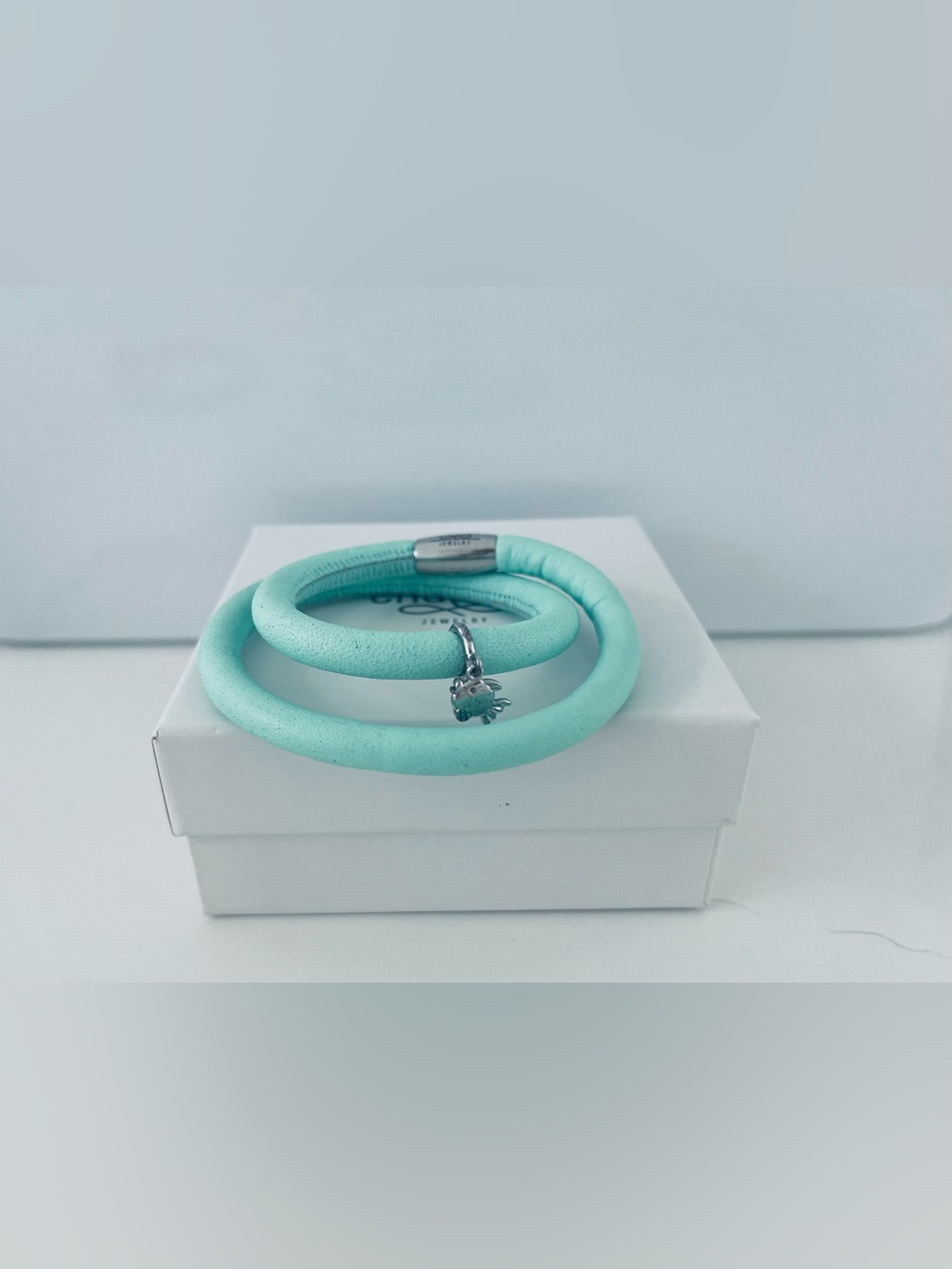 Double Leather Aqua Green Bracelet with silver fish dangling charm.